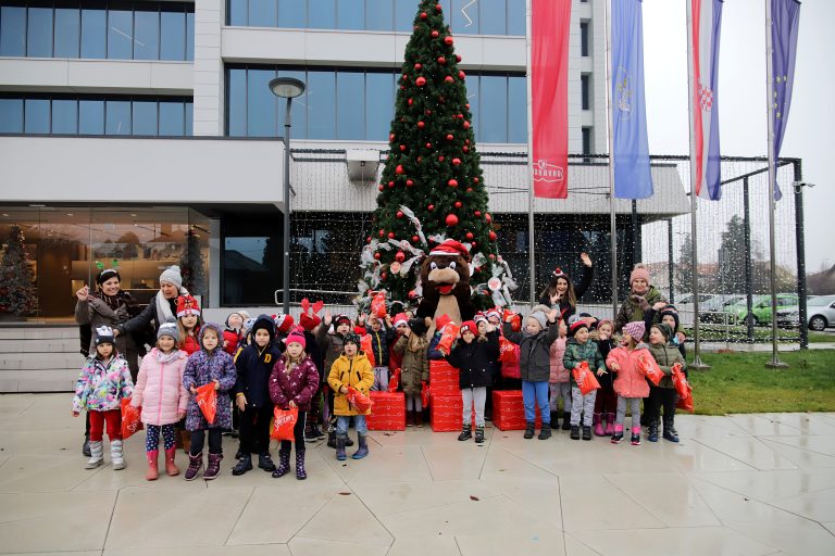 Veseli vrtićanci okitili božićno drvce ispred Podravkine zgrade